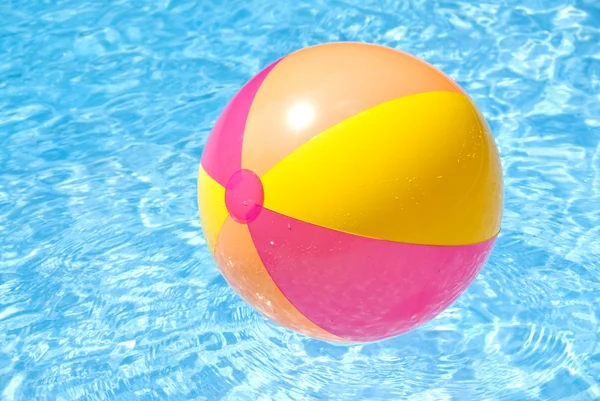 Bola de praia flutuando em uma piscina — Fotografia de Stock