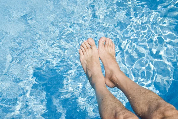 Pies sobre la piscina espumosa — Foto de Stock