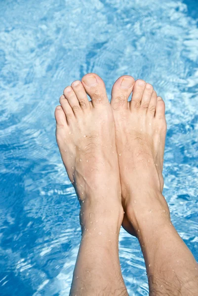 Pies sobre la piscina espumosa — Foto de Stock