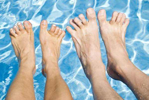 Pies sobre la piscina espumosa — Foto de Stock