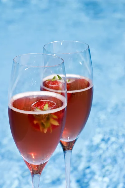 Dos copas de champán rosa y fresas junto a la piscina — Foto de Stock