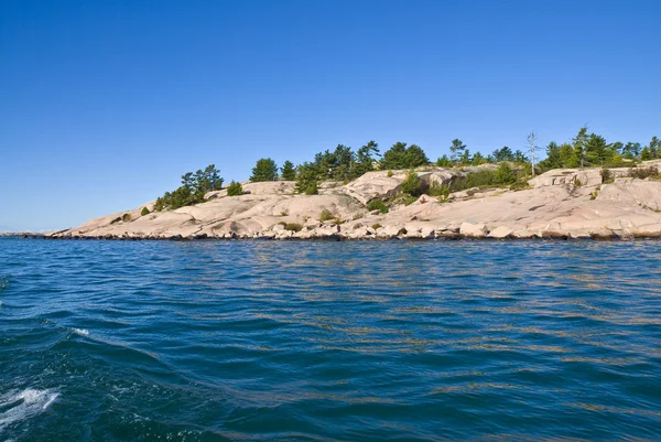 Roze graniet op de oever van het meer — Stockfoto