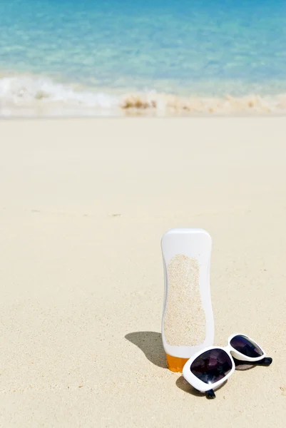 Gafas de sol y protector solar en una playa caribeña —  Fotos de Stock