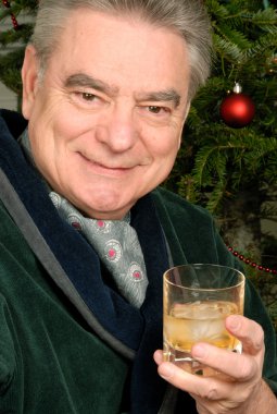 bir bardak viski tutan olgun adam