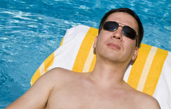 Homme se prélasser au bord de la piscine — Photo