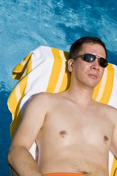 Człowiek wylegiwać się przy basenie — Zdjęcie stockowe