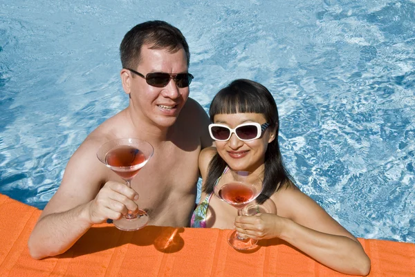 젊은 아시아 부부 수영장에서 핑크 마티니를 들고 — 스톡 사진