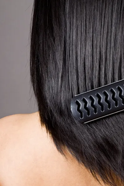 Mujer cepillándose el pelo largo y recto negro —  Fotos de Stock