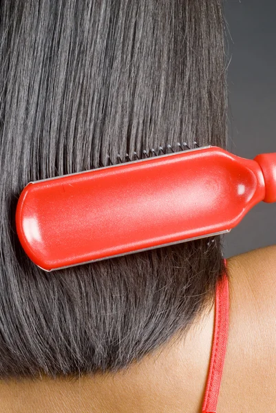 Mujer cepillándose el pelo negro recto —  Fotos de Stock