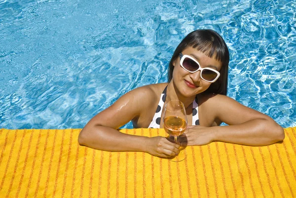 Femme avec un verre de vin dans une piscine — Photo