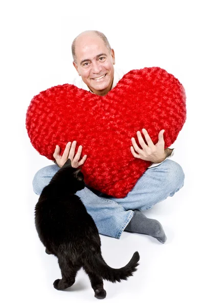 Mies, jolla on iso punainen sydän ja musta kissa — kuvapankkivalokuva