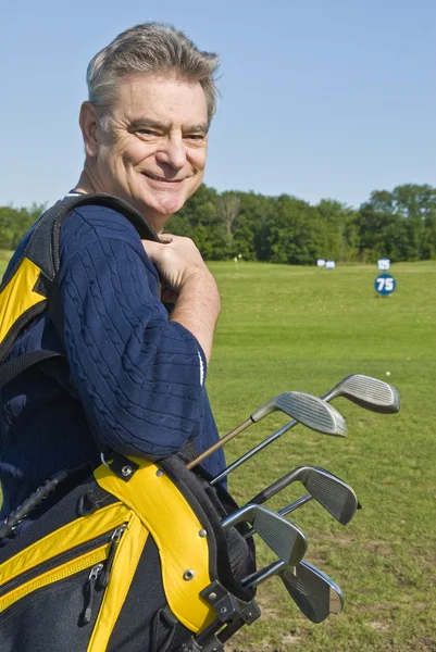 Homem carregando um saco de golfe (Caddy ) — Fotografia de Stock