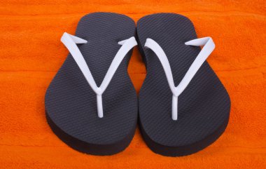 flip flop üzerinde turuncu plaj havlusu