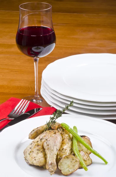 Kavrulmuş cornish tavuk ve kırmızı şarap ile servis kekik fışkın ile süslenmiş patates oyunu — Stok fotoğraf