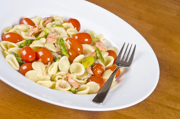 Massa com salmão selvagem defumado, tomate cereja de uva e espargos — Fotografia de Stock