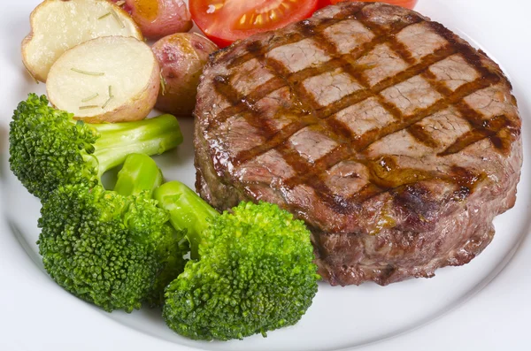 Grilovaný rib eye steak podávaný s brokolicí, brambory a rajčata — Stock fotografie