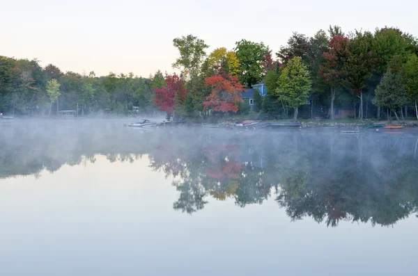 Riflessioni di colori autunnali e nuvole su un lago — Foto Stock