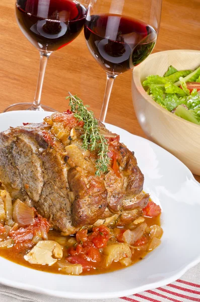 Cerdo asado servido con vino tinto y ensalada —  Fotos de Stock