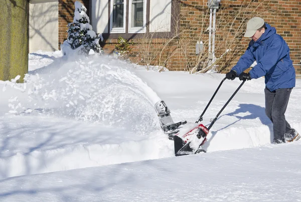 Homem usando o ventilador de neve para limpar a neve — Fotografia de Stock