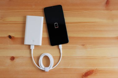 Powerbank giriş cep telefonundan USB şarj aleti ya da ahşap zemine akıllı telefon takın, Üst Görünüm.