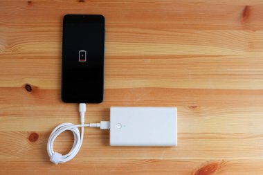 Powerbank giriş cep telefonundan USB şarj aleti ya da ahşap zemine akıllı telefon takın, Üst Görünüm.