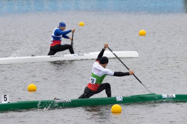 Barnaul, Rusya - 22 Mayıs 2021: Bulgar atlet A. Kodinov 2021 ICF Canoe Sprint Dünya Kupası ve Olimpiyat Seçmeleri 'nde C1 M dalında yarışıyor. Arka planda Rus atlet Sharov D..