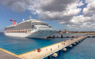Cozumel, Meksika - 12 Mart 2020 Cozumel 'e Karnaval Fethi yanaştı. Muhteşem turkuaz su ve ön planda turistler olan iskele. Arka planda bulutlu mavi gökyüzü.