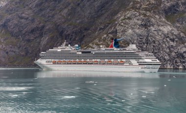 Alaska, ABD - 1 Eylül 2018: Alaska Fiyortlarından biriyle Splendor Karnavalı. Ön planda güzel turkuaz buzlu su, arka tarafta devasa dağ..