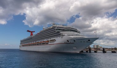 Cozumel, Meksika - 12 Mart 2020: Cozumel 'e yanaşan Karnaval Fetihinin alçak açılı çekimi. Ön planda muhteşem turkuaz su var. Bulutlu mavi gökyüzü ve arka planda iskele.