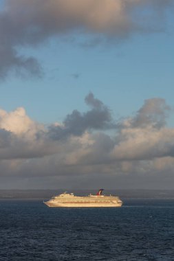 Saint Vincent and the Grenadines - 11 Mayıs 2020: Saint Vincent adası açıklarında denize demir atmış Karnaval Valor 'un Çekimi. Mavi bulutlu gökyüzü ve arka planda kıyı şeridi. Portre boyutu.