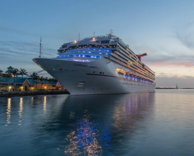 Nassau, Bahamalar - 22 Haziran 2019: Karnaval Özgürlük yolcu gemisi gün batımında Prens George Wharf 'a yanaştı. Arka planda mavi ve turuncu gökyüzü. Düşük açılı çekim. Mavi saatin başlangıcında.