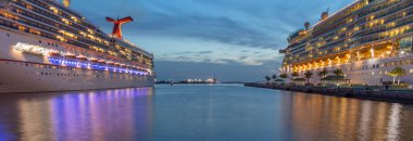 Nassau, Bahamalar - 22 Haziran 2019: Günbatımında Prens George Rıhtımı 'ndaki Deniz Piyadesi Özgürlük Karnavalı' nın güzel panoramik çekimi. Mavi saat. Önplandaki sudaki yansımalar.