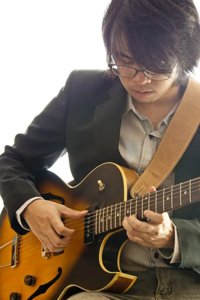 Asiatisk ung musiker spiller guitar - Stock-foto