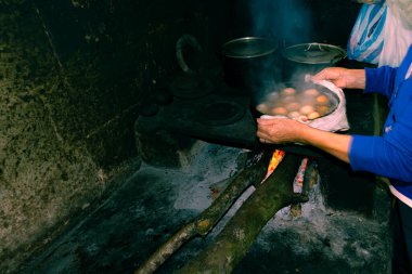 Ahşap ocakta yemek pişiren Latin bir köylünün elleri.