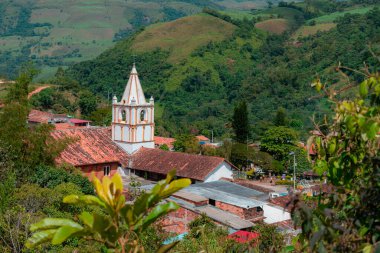 Kolombiya 'nın Ocamonte kasabası kilisesinin çatıları ve arka planında dağ olan kulesi.