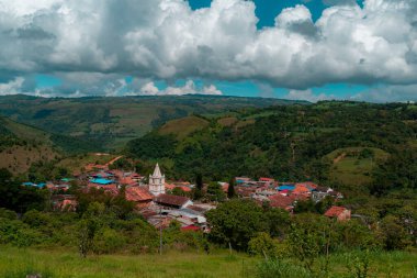 Kolombiya 'nın Ocamonte belediyesinin manzarası. Arka planda kilise kulesi ve dağlar var.