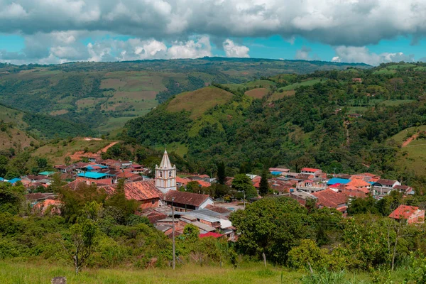 Kolombiya 'nın Ocamonte belediyesinin manzarası. Arka planda kilise kulesi ve dağlar var.