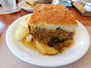 Mousaka, içinde et, patlıcan, patates ve bchamel sosu olan bir Yunan yemeği.