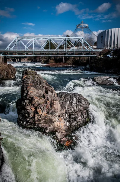 Aguas blancas corriendo alrededor de una enorme roca — Foto de Stock