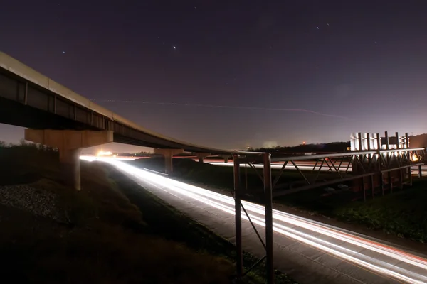 Trilhas de semáforo sob ponte — Fotografia de Stock