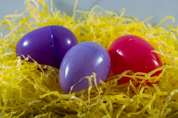 Colorful plastic easter eggs in fake hay — Stock Photo, Image