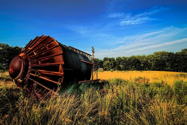 Old rusty rustic tower on its side in agricultural field — Stock Photo, Image
