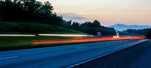 夕焼けの空に対して夜道路 — ストック写真