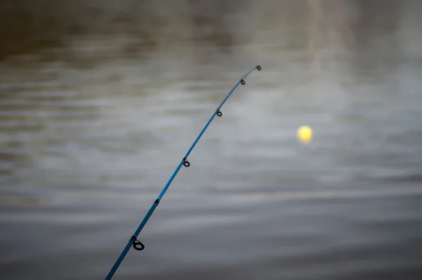 Рибальський полюс - боббер, що плаває в озері — стокове фото