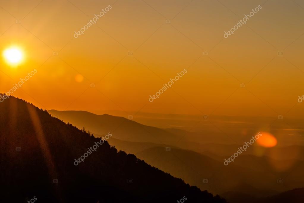 Sun rising over snowy mountains of Smokies in early spring with fog in valleys