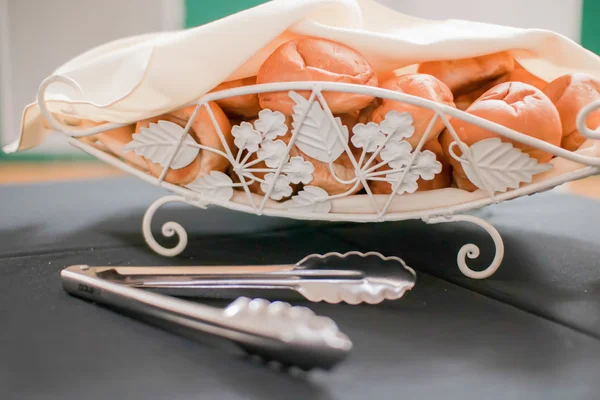 Tasty rolls lying on a white napkin in a basket — Stock Photo, Image