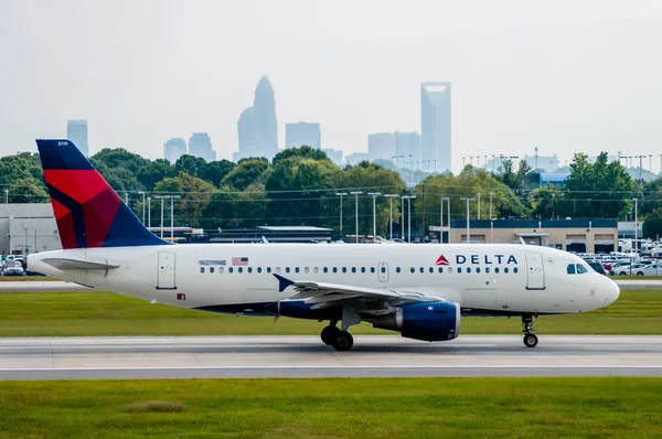 Jet commerciale su una pista aeroportuale con skyline della città nel bac — Foto Stock