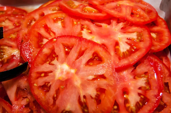 Gezonde natuurlijke voedsel, achtergrond. tomaten segmenten — Stockfoto