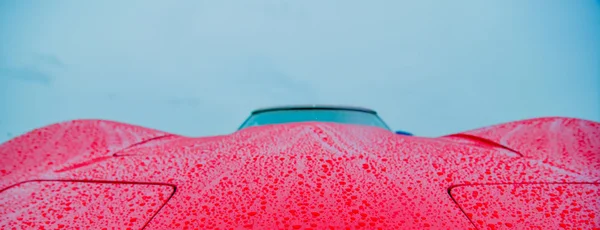 Czerwony sportowy samochód mokre od deszczu krople — Zdjęcie stockowe