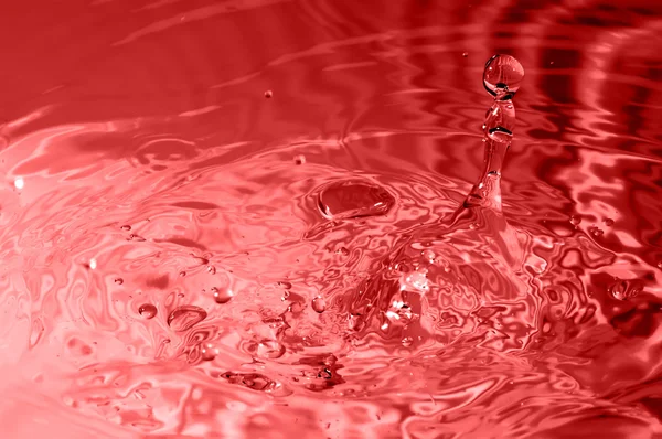 Red multi colored water drop bubbling — Stock Photo, Image